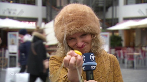 Reporterin Katja Kreml zerdrückt ein Ei.  