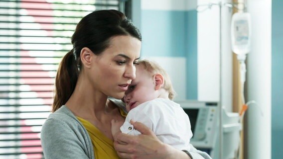 Eine Frau hält ein Baby in ihren Armen.  