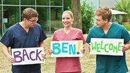 Stefan, Julia und Mikko halten Schilder in der Hand: back Ben welcome. © Screenshot 