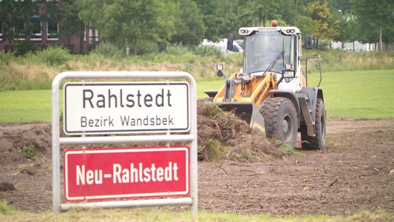 Công trình xây dựng cho Công viên Victoria: Một chiếc máy xúc đang đứng bên cạnh bảng tên địa danh "Rahlstedt".  © NDR