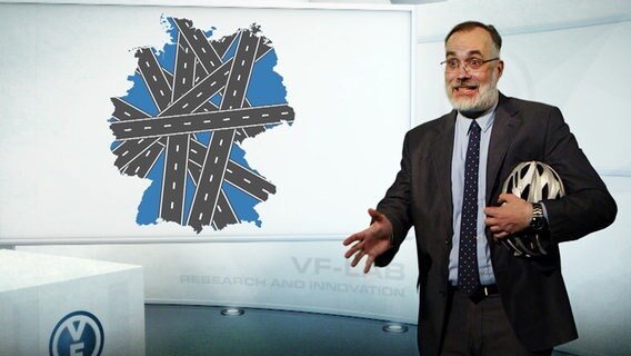 Ein Mann steht vor einer Deutschlandkarte mit Autobahnen  