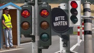 Ein sogenannter Verkehrshelfer steht unter einem Unterstand bei einer Pontonbrücke bei Bochum  