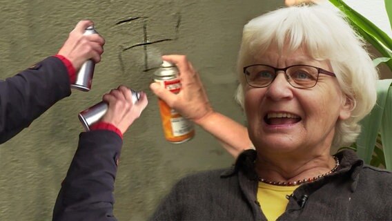 Die Frau zeigt ein von ihr verändertes Graffito.  