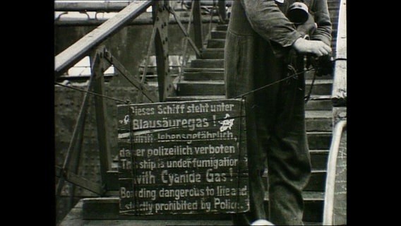Ein historisches Schild vor einem Schiff auf dem steht, dass man das Schiff wegen eines Blausäuregases nicht betreten darf. Ein historisches Schild vor einem Schiff auf dem steht, dass man das Schiff wegen eines Blausäuregases nicht betreten darf. © NDR