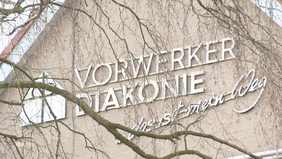 Logo der Vorwerker Diakonie in Lübeck auf einer Hauswand.  