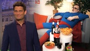 Christian Ehring und im Hintergrund der Corona-Superheld Sofaman  