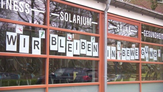 Schriftzug Wir bleiben in Bewegung in einem Fenster  