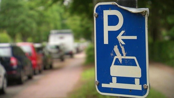 Ein verbeultes Blechschild weist Parkplätze in Langenhorn aus.  
