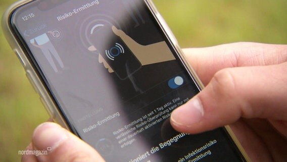 Ein Handy auf dessen Bildschirm die Corona-Warn-App zu sehen ist.  