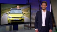 Christian Ehring und im Hintergrund ein Mann in einem kleinen Auto.  