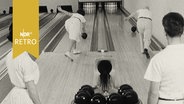 Ein Mann und eine Frau parallel beim Bowling  