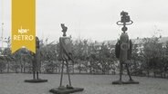 Drei Metallskulpturen in einem Garten  