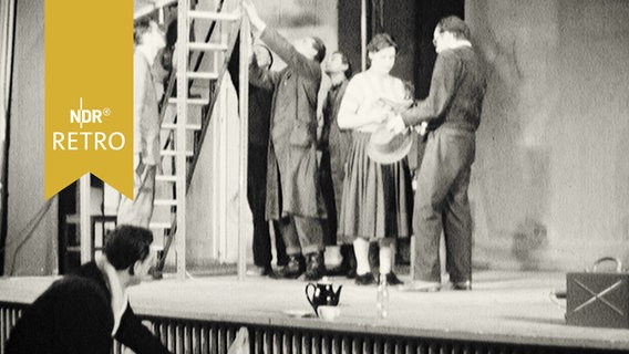 Schauspieler und Handwerker mit Lieter auf einer Bühne in einem Theater  