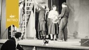 Schauspieler und Handwerker mit Lieter auf einer Bühne in einem Theater  
