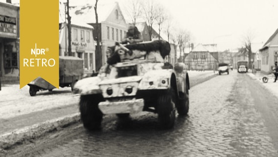 Panzerwagen unterwegs auf einer Dorfstraße  