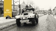 Panzerwagen unterwegs auf einer Dorfstraße  