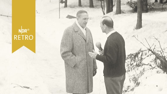 Zwei Männer stehen zum Interview auf angetauter Rodelbahn  