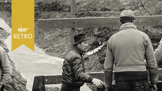 Männer stehen an einer Baustelle einer Brücke  