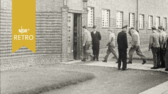 Gefangene betreten nacheinander das Zellengebäude im Jugendgefängnis Hahnöversand  