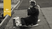 Hörfunkreporter (bei Fußballspiel) auf dem Tribünendach im Hoheluft-Stadion bei der Arbeit  