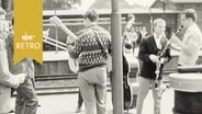 Mehrere Musiker auf einem Bahnsteig mit ihren Instrumenten  