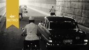Zwei Oldtimer und zwei Mopeds auf dem Weg zum Tunnelausgang  