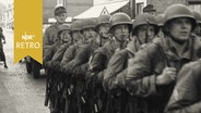 Kompanie der Bundeswehr marschiert in Formation durch Straße der Innenstadt von Munster  