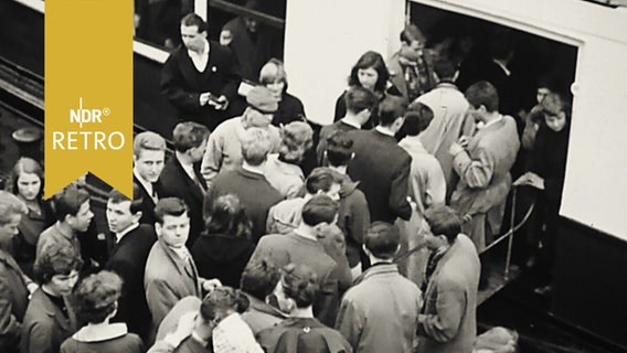 Zahlreiche Menschen drängen auf eine Fähre an den Landungsbrücken in Hamburg (1958)  