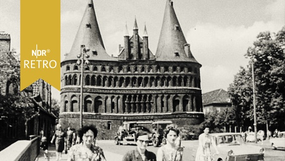 Holstentor in Lübeck mit Straßenverkehr im Vordergrund  