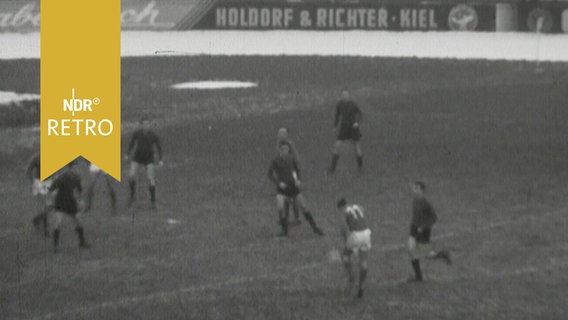 Fußballspieler in Aktion im Januar 1961 im verschneiten Holstein-Stadion in Kiel  