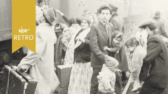 Menschen steigen aus einem Zug in Büchen (1959)  