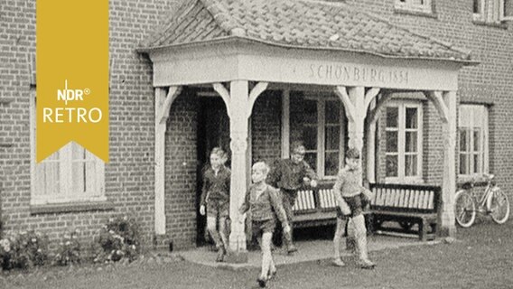 Kinder kommen aus dem Eingang eines Wohnheims (Rauhes Haus) in Hamburg (1958)  