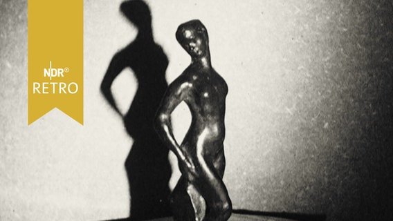 Skulptur einer Frauenfigur aus Bronze auf einem Tisch  