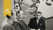 Minderheitenführer Harro Marquardsen und Berthold Bahnsen vor Karte des dänisch-deutschen Grenzgebiets im Fernsehstudio beim Interview  