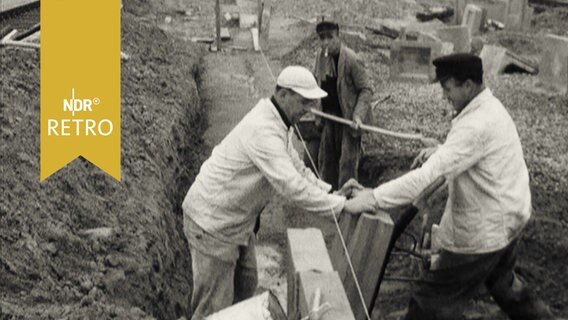 Zwei Bauarbeiter beim Errichten einer Mauer (1959)  