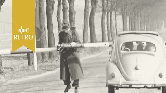 Grenzer öffnet eine Schranke für einen VW Käfer an der innerdeutschen Grenze bei Lauenburg 1959  