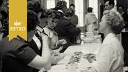 Frauen drängen sich an einen Messestand der Hausfrauenmesse in Hannover 1960  