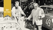 Teilnehmer der Straßenrallye Tour d'Europe an ihren PKW im Gespräch (1960)  