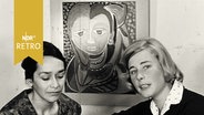 Journalistin mit der Künstlerin Nan-Cuz-Schaefer vor einem ihrer Gemälde beim Interview  