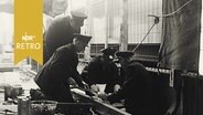 Vier Gleisarbeiter in schicken Uniformen beim Schienenverlegen in Hamburg 1960  