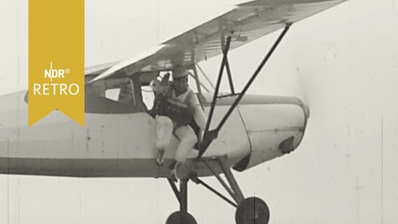 Fallschirmspringer kurz vor dem Absprung aus einer Propellermaschine (1960)  