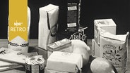 Etliche Lebensmittelpackungen auf einem Tisch (1960)  