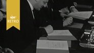 Fünf Herren unterzeichnen je eine Abschrift eines Vertrages (1961)  