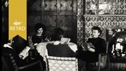 Vier Frauen sitzen in einer Lounge und lesen in Büchern oder Zeitschriften (Müttergenesungsheim Plön, 1961)  