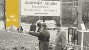 Drei junge Männer folgen einem Wegweiser zu den "Alsterdorfer Anstalten" (1961)  