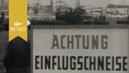 Schild "Achtung Einflugschneise", im Hintergrund Baustelle der Messe Hannover 1961  