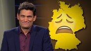 Nils Holst steht vor einem Banner mit der Aufschrift "Der Osten sagt Danke".  