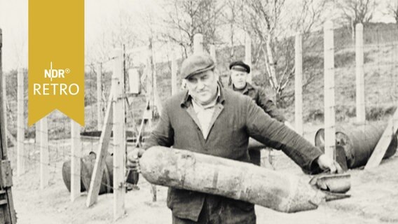 Ein Mann trägt eine ausgegrabene Weltkriegsbombe (1961)  