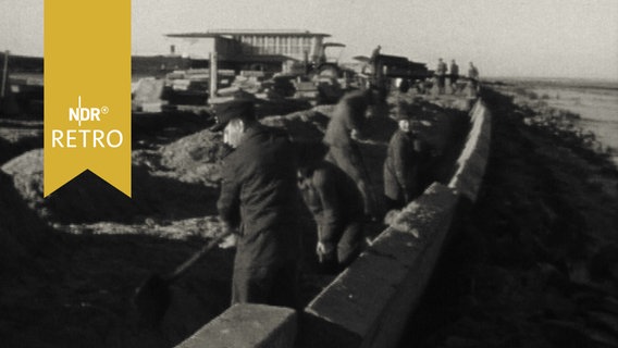 Helfer bei Aufräumarbeiten nach der großen Flut in Norddeutschland (1962)  