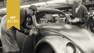 Zwei Arbeiter bei der Montage eines VW-Käfers in der Produktionsstätte in Wolfsburg (1961)  